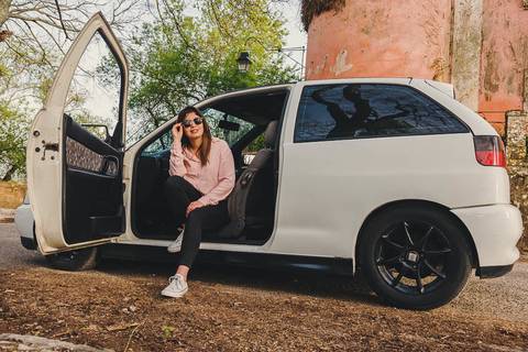 Myriam Correia sentada com estilo na porta aberta do Seat Ibiza durante sessão de retrato individual na Quinta da Cardiga, Golegã. O carro como extensão da sua identidade. Duo Capuano Fotografia.'