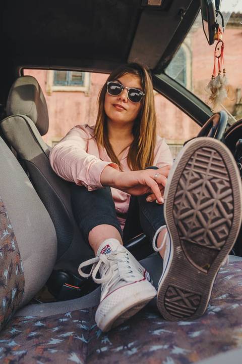 Myriam Correia dentro do Seat Ibiza em pose relaxada durante sessão de retrato feminino na Quinta da Cardiga, Golegã. Um momento íntimo e autêntico que revela confiança. Duo Capuano Fotografia.'