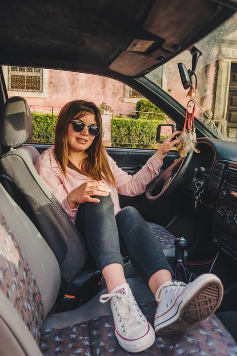 Myriam Correia ao volante do Seat Ibiza com óculos de sol em retrato descontraído na Quinta da Cardiga, Golegã. Confiante e radiante numa das suas maiores paixões. Duo Capuano Fotografia.'