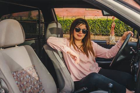 Myriam Correia dentro do Seat Ibiza em pose elegante com óculos de sol durante sessão de retrato feminino na Quinta da Cardiga, Golegã. Confiança e estilo num único olhar. Duo Capuano Fotografia.'