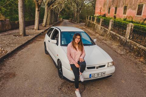 Myriam Correia junto ao seu Seat Ibiza numa estrada entre árvores, durante sessão de retrato feminino na Quinta da Cardiga, Golegã. O carro e o ambiente natural em harmonia perfeita. Duo Capuano.'