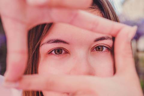 Close-up do rosto de Myriam Correia enquadrado pelas suas mãos durante sessão de retrato feminino na Quinta da Cardiga, Golegã. O olhar que enquadra o mundo — e o mundo que a enquadra. Duo Capuano.'