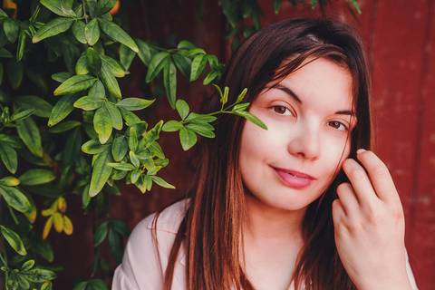 Myriam Correia entre folhagem verde durante sessão de retrato feminino na Quinta da Cardiga, Golegã. Um momento de leveza e naturalidade num cenário exuberante. Duo Capuano Fotografia.'