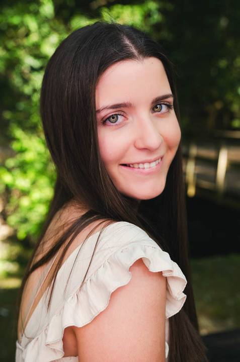 Retrato feminino com sorriso genuíno entre folhagem verde – sessão de fotografia ao natural no Parque do Bonito, Santarém'
