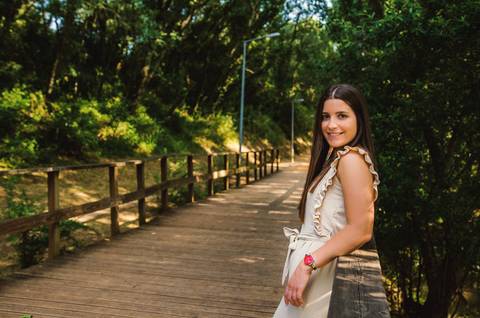 Mulher sentada na ponte de madeira com postura descontraída – retrato feminino ao ar livre no Parque Verde do Bonito, primavera'