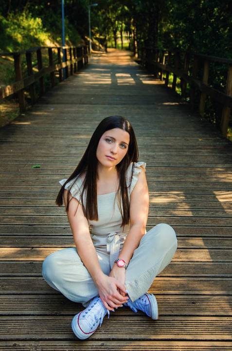 Retrato feminino sentada de lado na ponte com postura natural – fotografia de retrato ao ar livre no Parque do Bonito, Santarém, primavera'