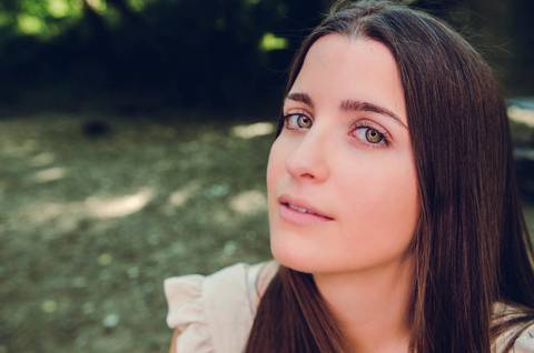 Retrato feminino sentada no chão do parque com postura relaxada – sessão fotográfica de retrato na primavera, Parque do Bonito, Santarém'
