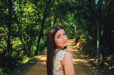Retrato feminino num trilho de areia iluminado pelo sol – fotografia de retrato ao ar livre no Parque Verde do Bonito, Santarém, primavera'