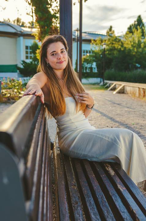 Detalhe de colar delicado ao pescoço. Retrato feminino suave com sorriso espontâneo e cabelo louro. Sessão fotográfica individual da Susana ao ar livre em Torres Novas por Duo Capuano.'
