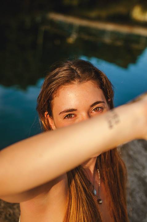 Retrato criativo com detalhe de braço e olhos expressivos. Pose artística de Susana no lago de Torres Novas com luz azul ao entardecer. Sessão fotográfica feminina individual por Duo Capuano.'
