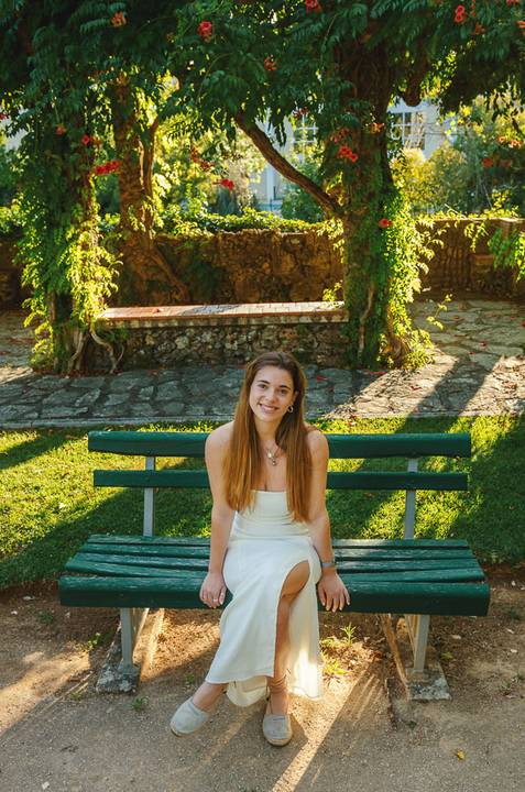 Fotografia feminina individual com Susana em vestido branco e pose confiante entre muros cobertos de folhagem. Jardim das Rosas, Torres Novas. Sessão ao ar livre por Duo Capuano Fotografia.'