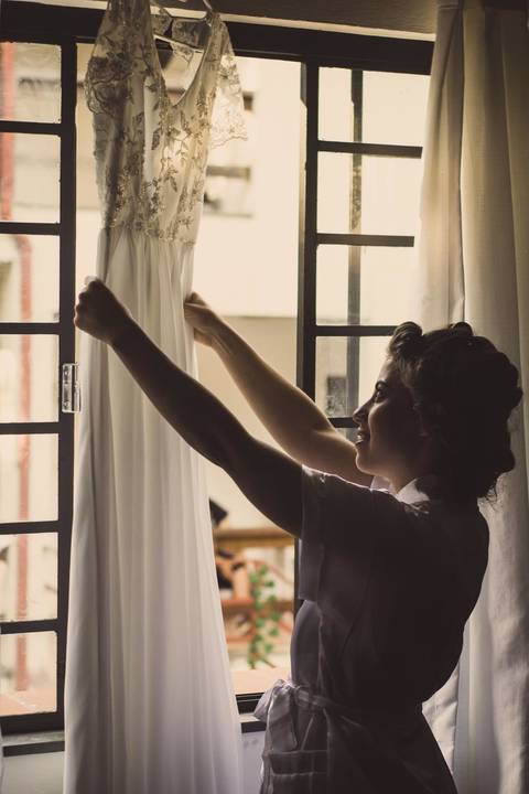 Noiva Camila durante preparação da noiva com penteado e maquiagem para casamento em São Paulo, mulher usando roupa rosa durante arrumação na cerimônia'