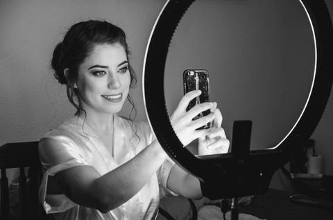 Retrato em preto e branco da noiva Camila apontando para câmera durante preparação para casamento em São Paulo'