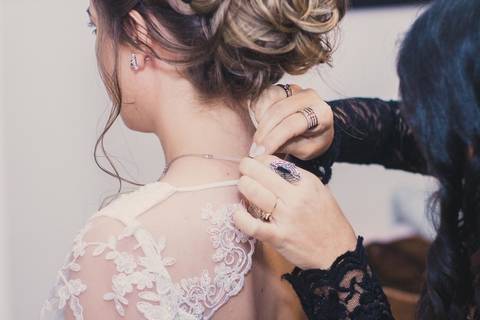 Momento de ajeitar o fechamento do vestido da noiva Camila antes da cerimônia de casamento em São Paulo, detalhe de renda do vestido branco'