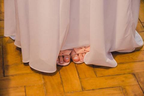 Detalhe dos sapatos da noiva em tons de ouro ao lado do vestido branco de renda para casamento em São Paulo, calçado feminino elegante'