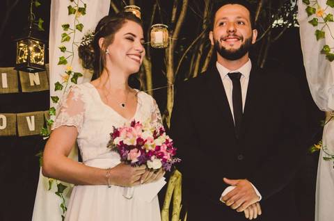 Casal Camila e Rafael posando abraçados durante festa de casamento com decoração ao fundo em São Paulo, retrato do casal na pista'