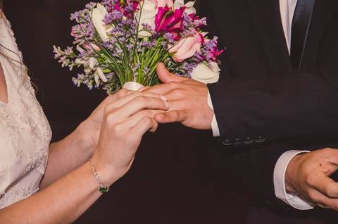 Casal Camila e Rafael em preto e branco durante cerimônia com flores ao fundo para casamento em São Paulo'