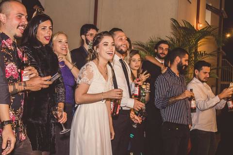 Convidados dançando e comemorando durante festa de casamento Camila e Rafael em São Paulo com noiva em primeiro plano'