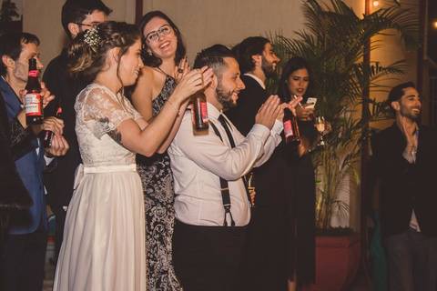 Convidados em preto e branco dançando durante festa de casamento Camila e Rafael em São Paulo com casal em primeiro plano'