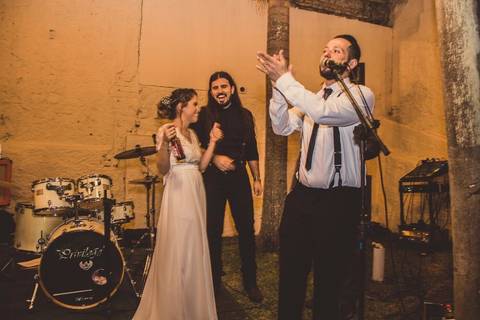 Músico tocando trompete durante banda ao vivo em casamento Camila e Rafael em São Paulo em ambiente escuro'