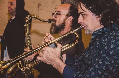 Noiva Camila com buquê de flores magenta e brancas durante festa de casamento em São Paulo com decoração ao fundo'