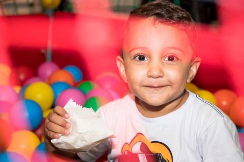 criança feliz na piscina de bolinha da festa infantil no tema princesas'