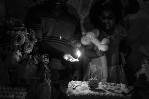 acendendo a vela do bolo em festa infantil no tema princesas'