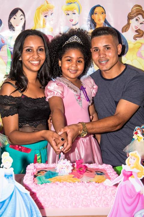 familia feliz em festa infantil no tema princesas, corte do bolo'