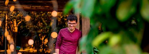 moda, luxo, ensaio masculino portrait do fotografo em sao paulo na avenida paulista sentado no meio da rua com seu look branco e  seus oculos no por do sol golden hour, cachos'