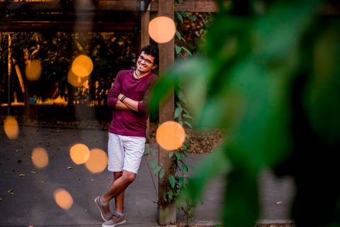 moda, luxo, ensaio masculino portrait do fotografo em sao paulo na avenida paulista sentado no meio da rua com seu look branco e  seus oculos no por do sol golden hour, cachos'