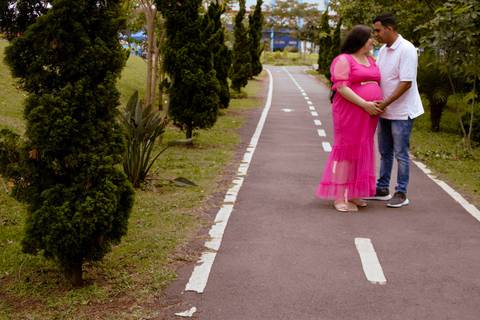casal posando em uma estrada no Parque Max Feffer durante um ensaio de gestante'