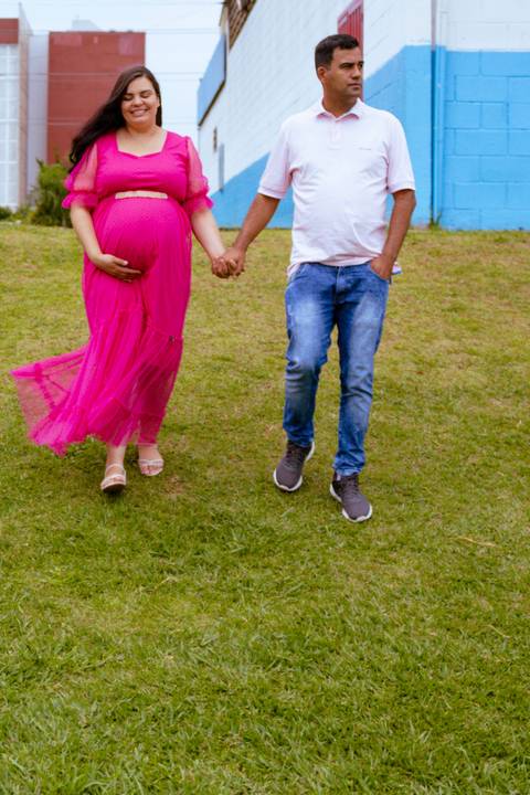 casal descendo uma ladeira durante um ensaio de gestante'