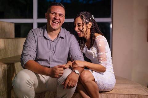 Casal sentado na escada gargalhando'