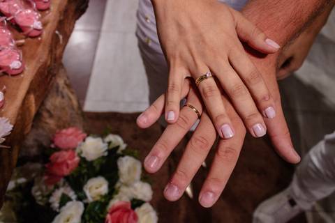mãos com alianças após noivado'