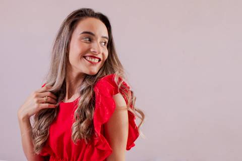 Ensaio de aniversário. A mulher está de vestido vermelho e olhando para o horizonte foto de Mary Santtiago'