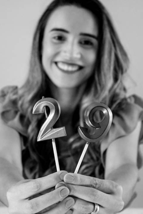 Foto preta e branca de uma mulher segurando uma vela de 29 anos em seu ensaio de Aniversário foto de Mary Santtiago
'
