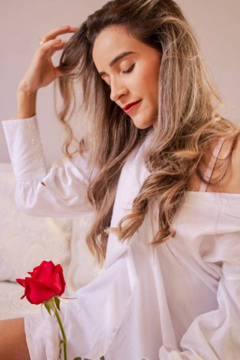 mulher de roupa branca com a mão no cabelo Mary Santtiago'