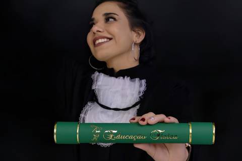 formanda segurando canudo de Educação Física, foto de Mary Santtiago Fotógrafa de Suzano'