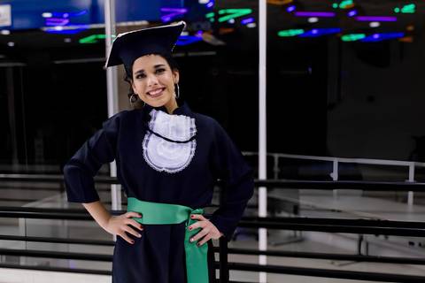 Formanda de Educação Física posando para foto com luzes ao fundo , Foto de Mary Santtiago'