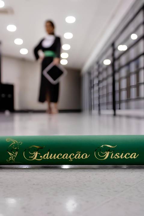 Canudo de Educação física com formanda desfocada ao fundo, Foto de Mary Santtiago'