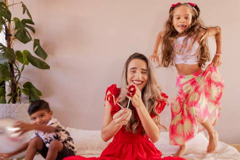 Crianças pulando na cama enquanto mãe faz ensaio fotográfico de aniversário'