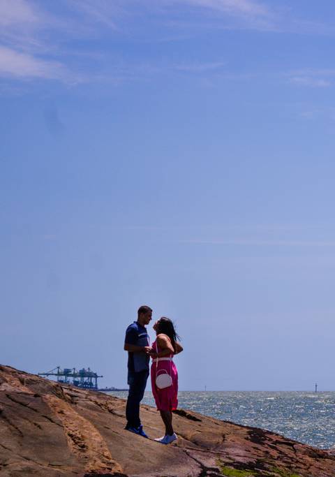 Casal posando para ensaio fotográfico na Praia Secreta de Vila Velha Espírito Santo, com vista para o Porto de Vitória. Ensaio de Bodas de Trigo feito por Mary Santtiago, fotógrafa de Suzano SP'