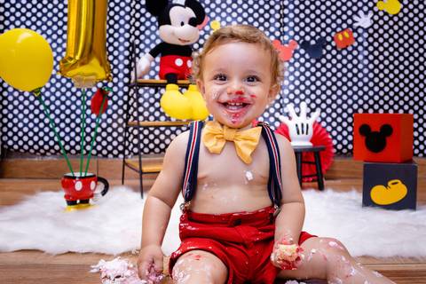 bebe sujo de bolo do Ensaio Smash the cake sorri para a foto'