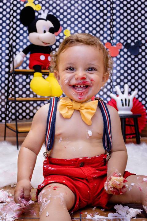 close de uma risada cheia de bolo do Ensaio Smash the Cake do Murilo'