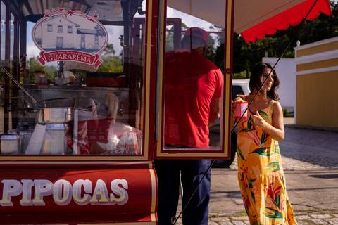 Gestante em um ensaio de Gestante comprando pipoca no meio do ensaio para matar um desejo. Fotografia de Mary Santtiago'