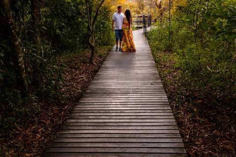 Foto de Casal passeando em uma calçada de madeira em um parque de Guararema SP, num ensaio de Gestante feito por Mary Santtiago'