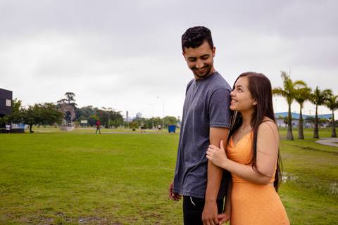 Nelly está segurando o braço do Matheus e eles estão se olhando e curtido esse momento romântico no Ensaio Pré-wedding realizado no Parque Max Feffer e as fotos foram feitas por Mary Santtiago'