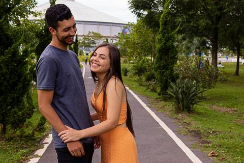 casal sorridente e tímido no inicio da sessão fotográfica do ensaio Pré-Wedding feito por Mary Santtiago, realizado em Suzano no Parque Max Feffer'