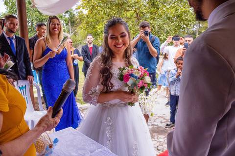 Noiva sorrindo e mãe do noivo ao fundo. Foto de Mary Santtiago em Suzano SP'