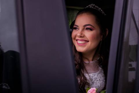 Noiva sorrindo lindamente no carro enquanto aguarda sua entrada para a cerimonia. Foto feita por Mary Santtiago em Suzano SP'